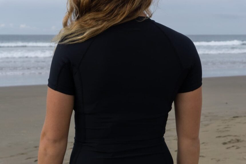 Our tester wearing a black short-sleeved O'Neill rash guard, seen from behind on the beach