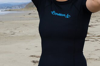 Our tester wearing the black O'Neill Basic Skins short sleeve rash guard on the beach