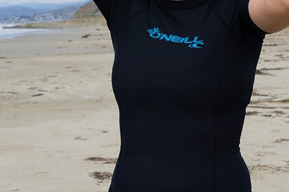 Our tester wearing the black O'Neill Basic Skins short sleeve rash guard on the beach