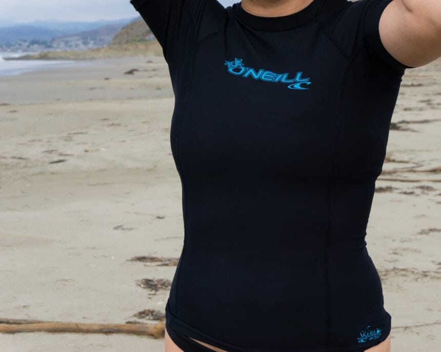 Our tester wearing the black O'Neill Basic Skins short sleeve rash guard on the beach