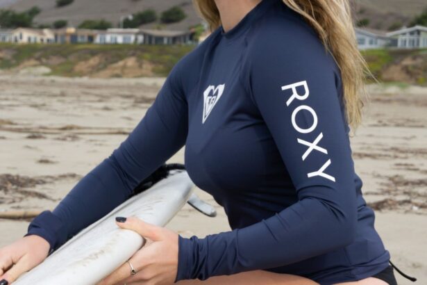 Our tester carrying a surfboard in the navy Roxy Whole Hearted long sleeve rash guard