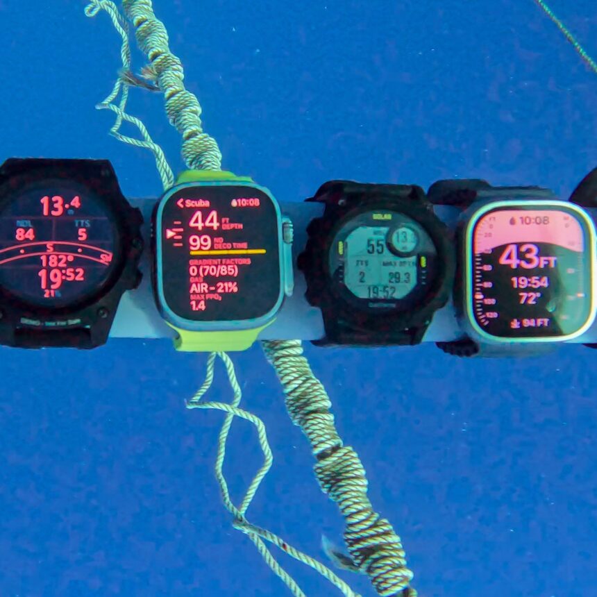 Dive Computers Compared At Depth Dive computers mounted on a bar underwater, all showing depth and time during a comparison dive