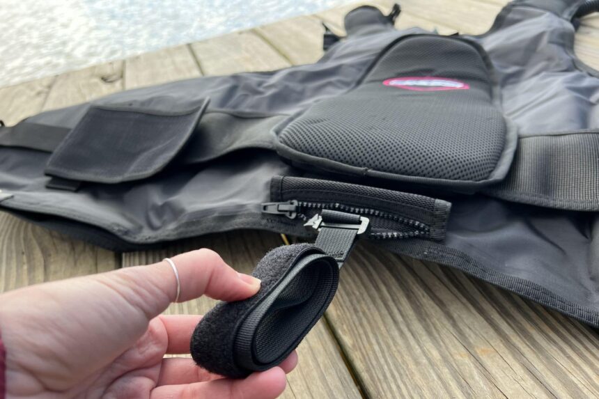 Our tester pulling a removable weight pocket from the zippered opening on the Cressi Travelight BCD