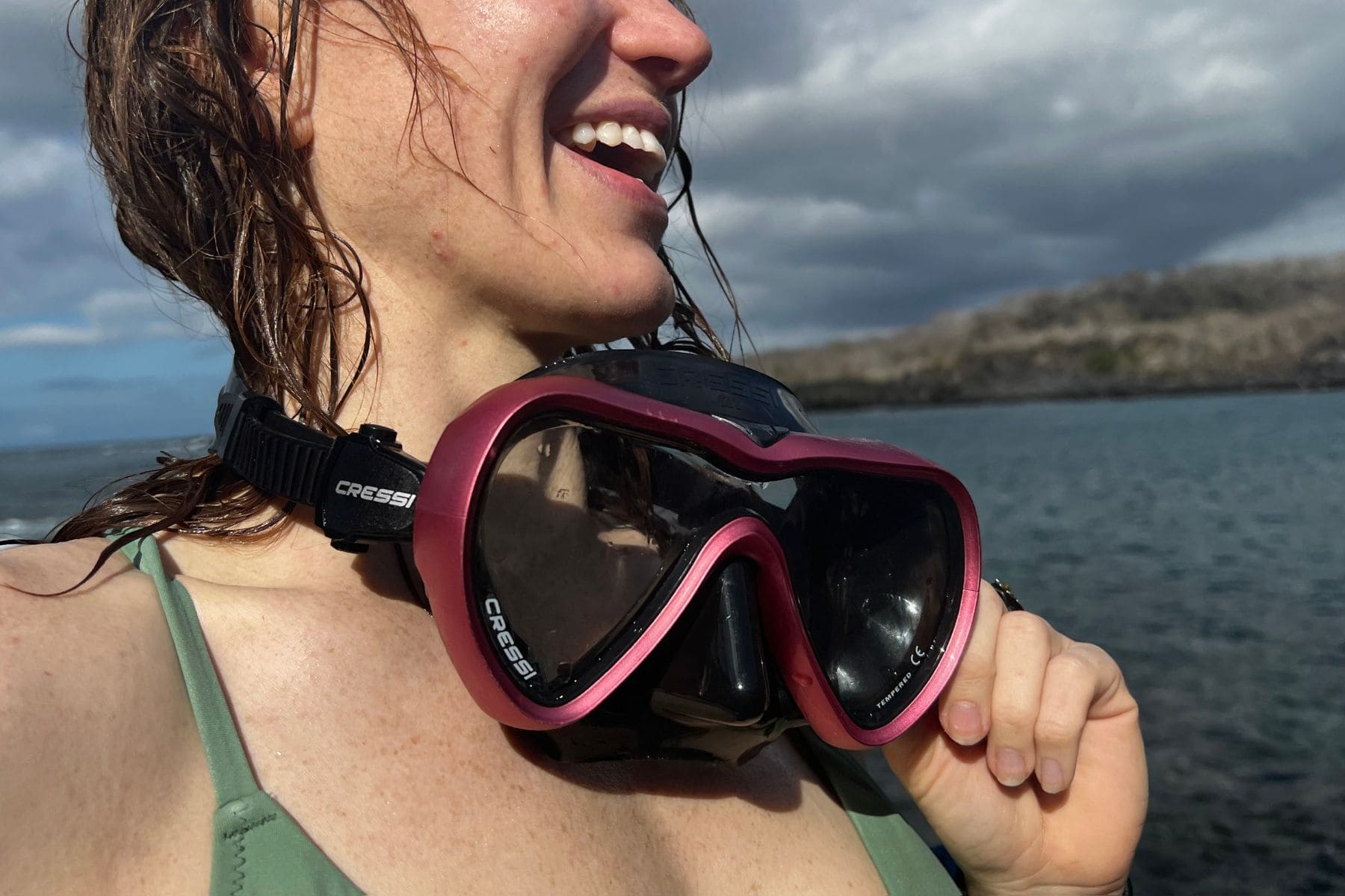 Our tester on a boat with the pink and black Cressi A1 mask resting around her neck after a dive