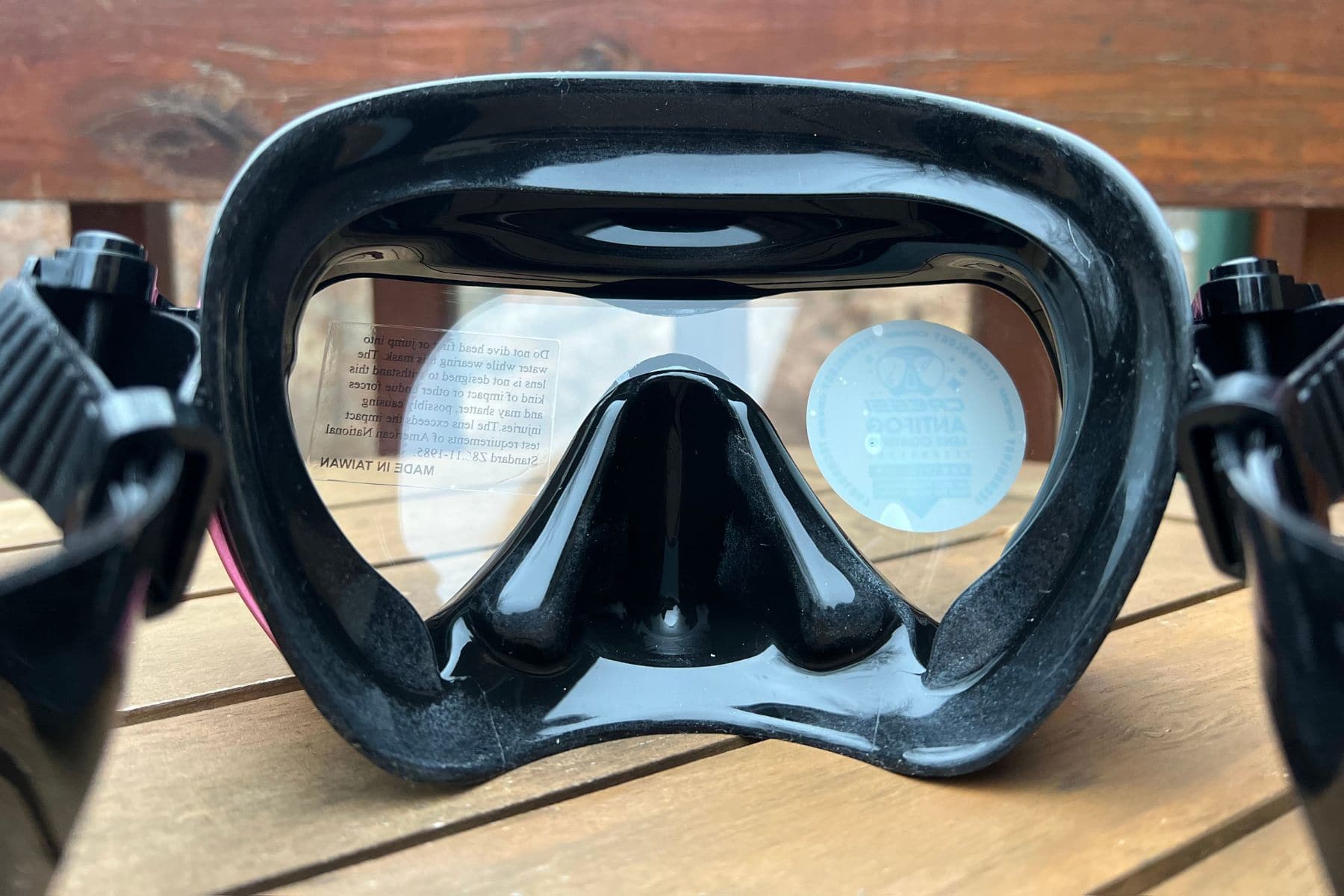 Rear view of the Cressi A1 mask showing its black silicone skirt and nose pocket on a wooden table