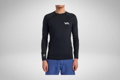 Man wearing a black RVCA long sleeve rash guard with a white VA chest logo and blue boardshorts
