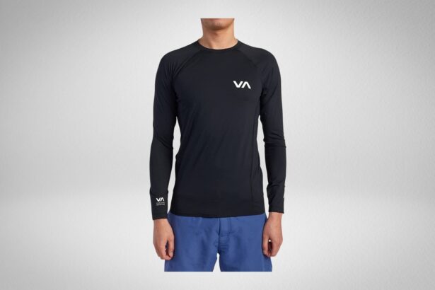 Man wearing a black RVCA long sleeve rash guard with a white VA chest logo and blue boardshorts