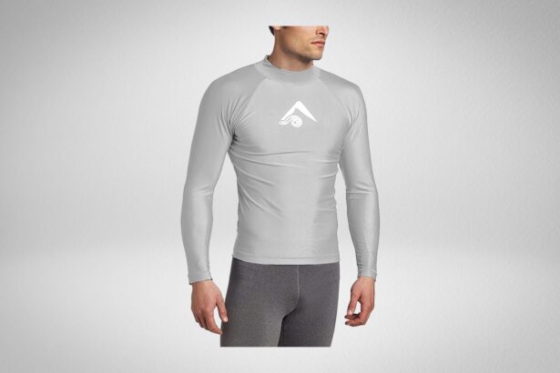 Man wearing a light grey Kanu Surf long sleeve rash guard with a white wave logo on the chest