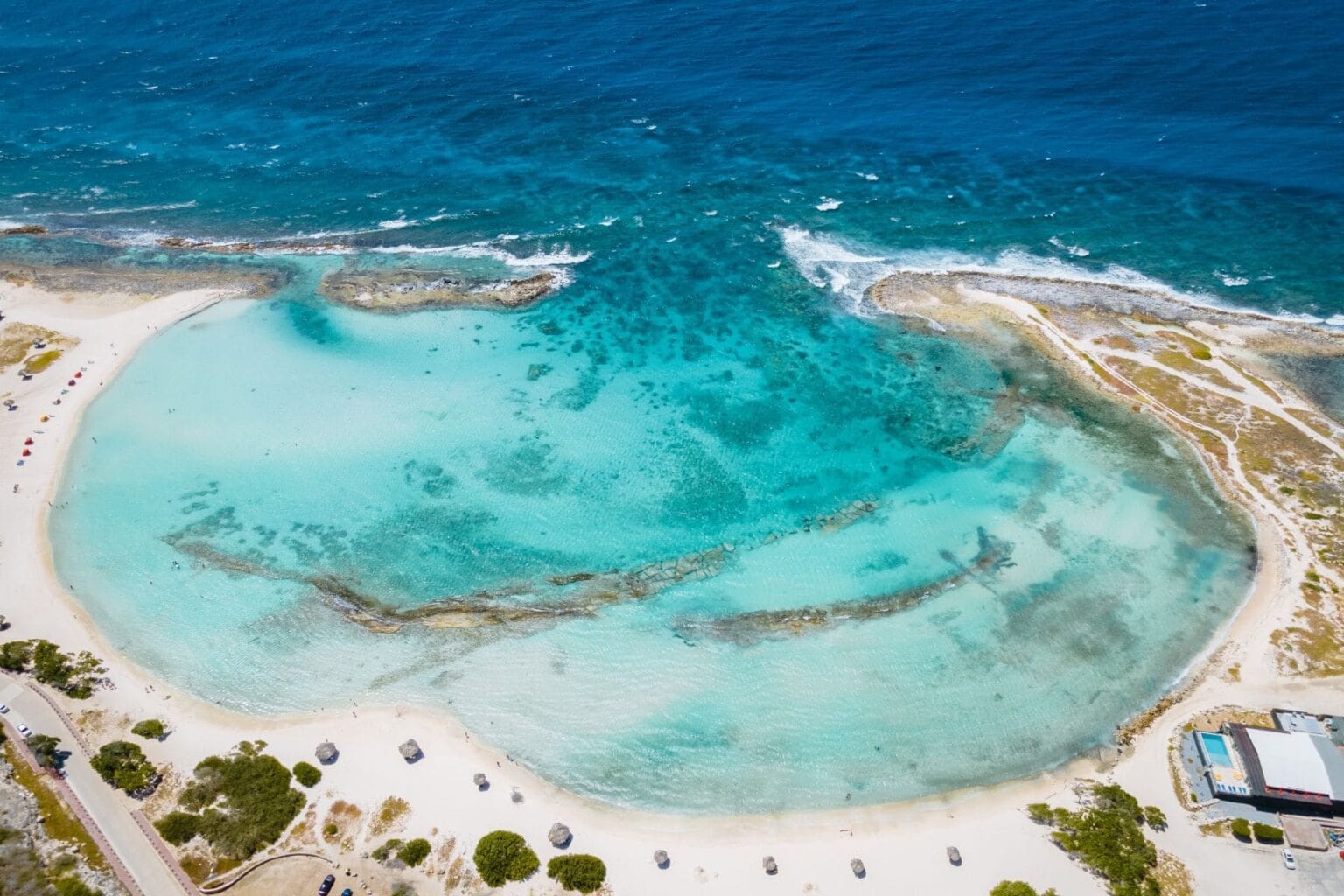 Aerial view of the sheltered turquoise cove at Baby Beach in Aruba