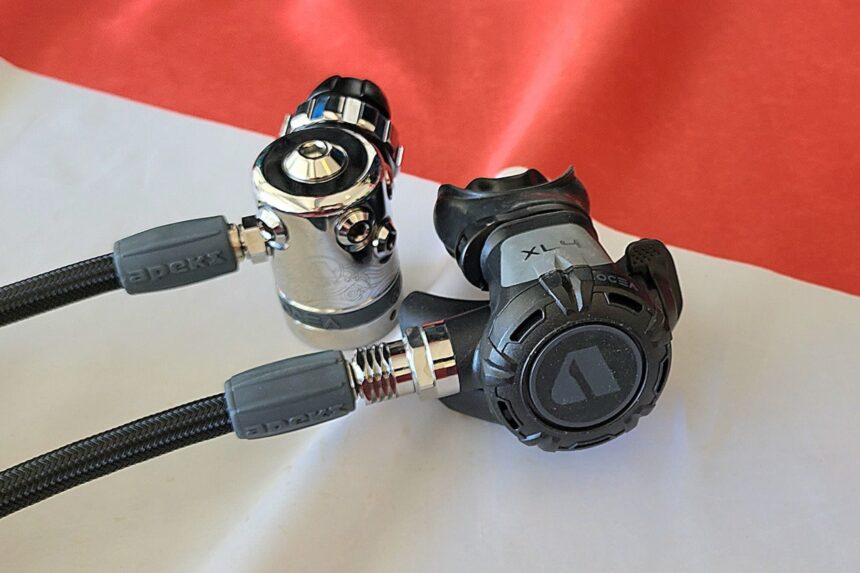 Apeks Ocea First Stage With XL4 Second Stage Apeks Ocea chrome first stage with hoses attached, next to the black XL4 second stage on a red and white surface