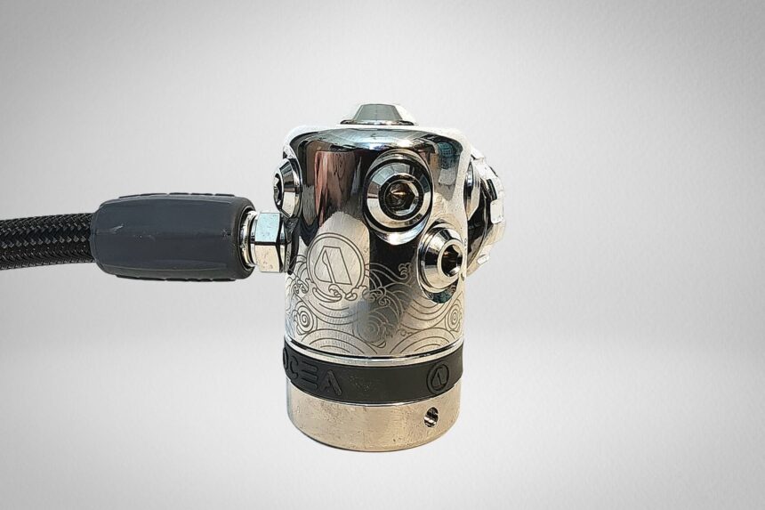 Apeks Ocea chrome first stage seen close up with its low and high pressure ports and etched ocean wave design