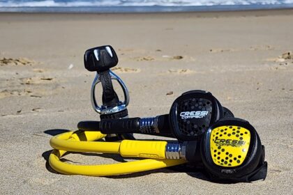 Cressi XS Compact AC2 first stage, second stage and yellow octopus resting on wet sand