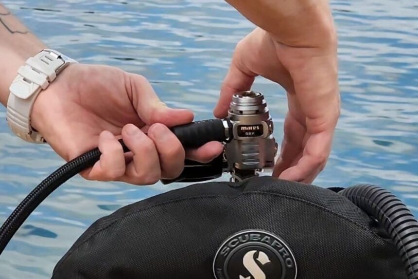 Our tester attaching the Mares 62X first stage to a Scubapro BCD beside a pool