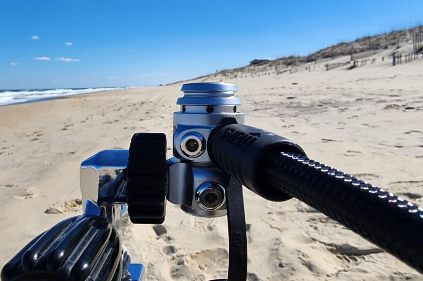 Mares 62X first stage with a DIN connection and hose routed off to the side on a beach