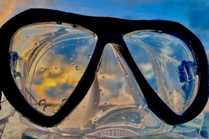 Close-up of the Genesis Icon mask lenses with water droplets and a sunset reflected in the glass