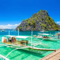 Traditional outrigger boats moored in the turquoise lagoon of Coron Bay, Philippines