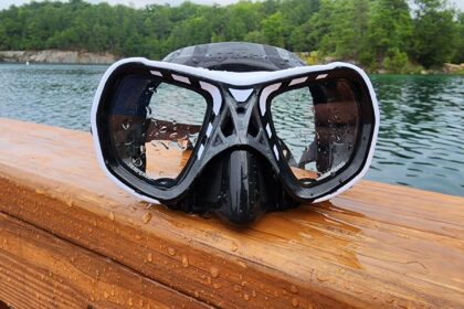Mares Spyder twin lens mask in white and black, wet on a wooden rail beside a lake