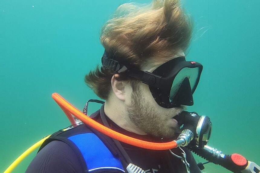 Side profile of our tester underwater in the Hollis M1 with the mask strap across his head