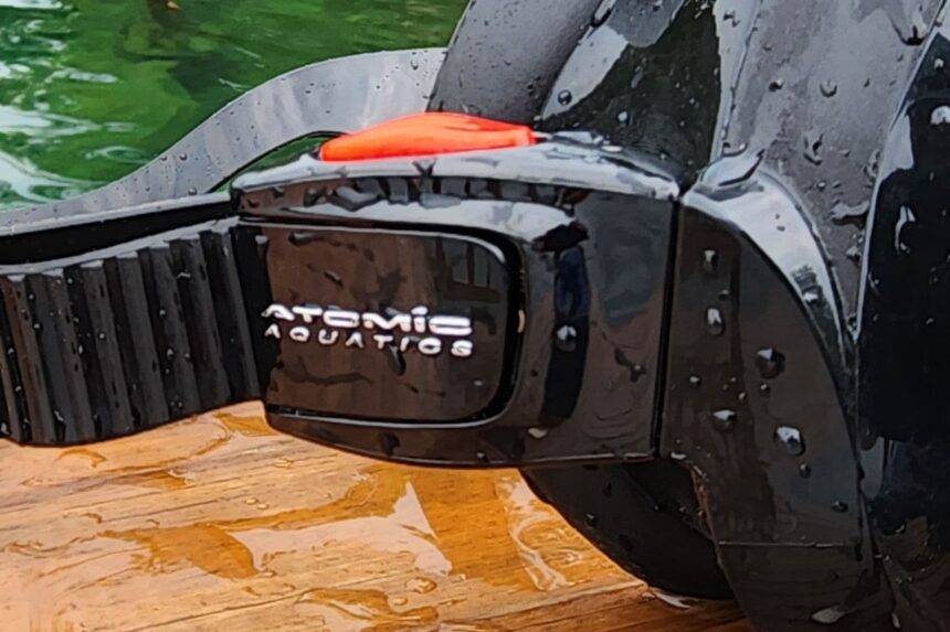Close-up of the Atomic Aquatics buckle and branding on the wet Venom frameless mask