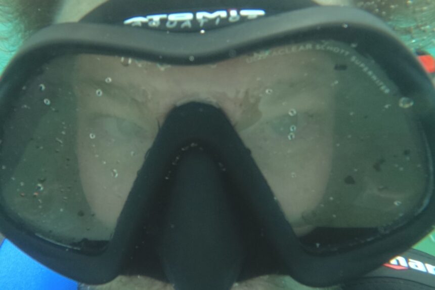 Close-up of our tester's face behind the Venom lens underwater, nose pocket against the brow