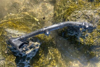 Oceanic Pocket folding snorkel resting on wet rocks in shallow clear water during DIVEIN testing