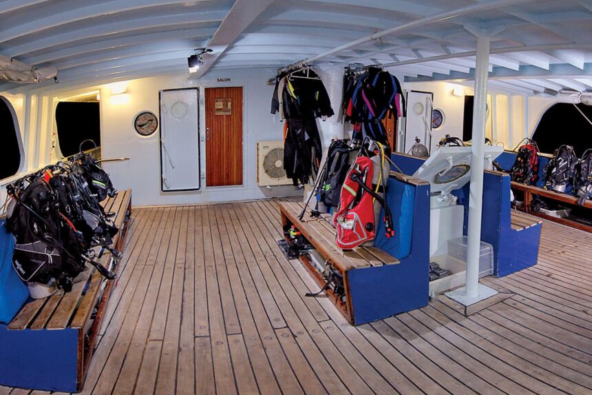 Wetsuits and dive gear hang ready on the Nai'a's covered dive deck