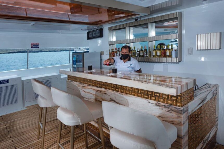 A masked bartender pours drinks at the Tiburon Explorer's onboard bar
