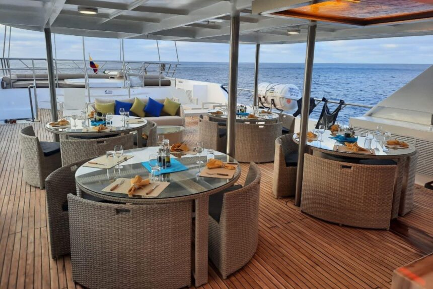 Outdoor dining tables set for guests on the Tiburon Explorer's deck