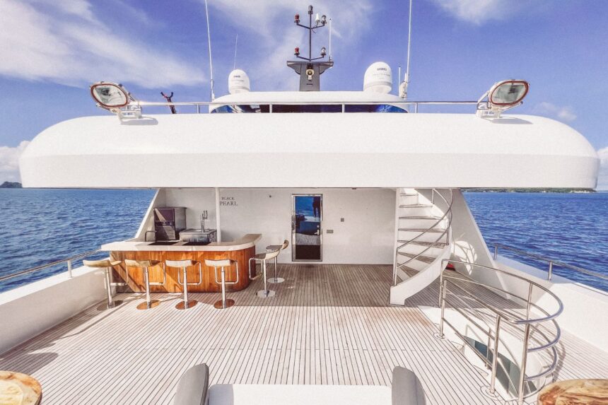 Upper deck of the Black Pearl Explorer with bar seating and spiral stairs at sea