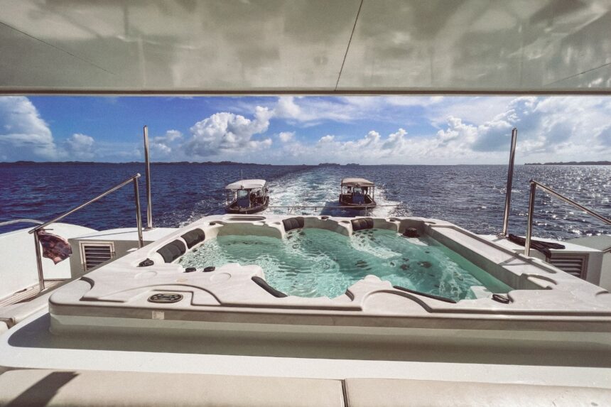 Outdoor hot tub on the Black Pearl Explorer's deck with dive tenders trailing behind