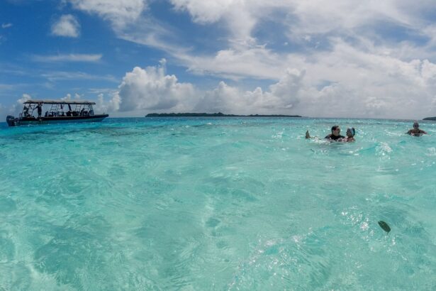 Guests snorkeling in Palau's shallow turquoise waters with a dive tender anchored nearby