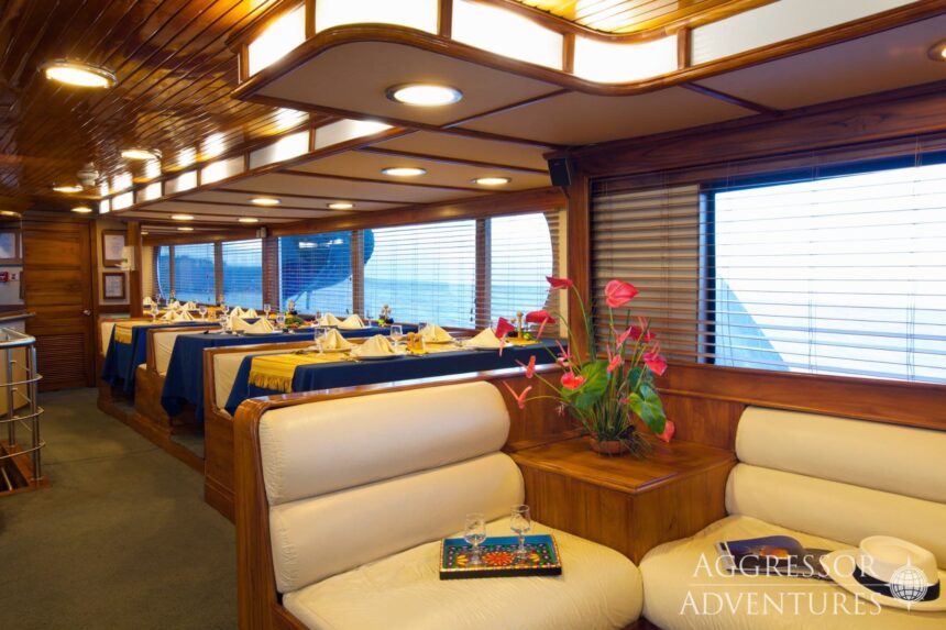 Dining area set with tablecloths and flowers aboard the Galapagos Aggressor III