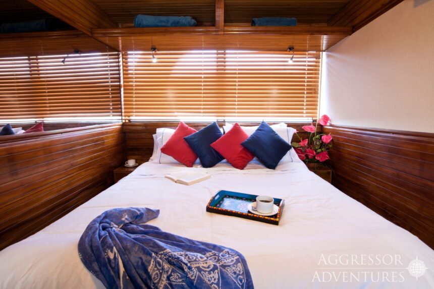 Cabin bed with breakfast tray and pillows aboard the Galapagos Aggressor III