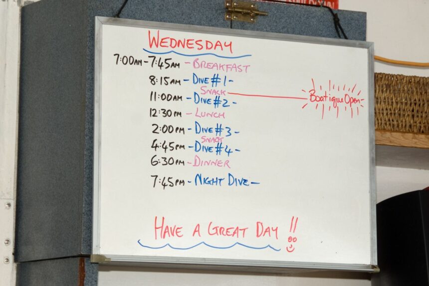 Whiteboard listing the day's dive schedule aboard a liveaboard