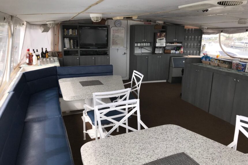 Salon lounge with blue booth seating and dining tables aboard the Caribbean Explorer II
