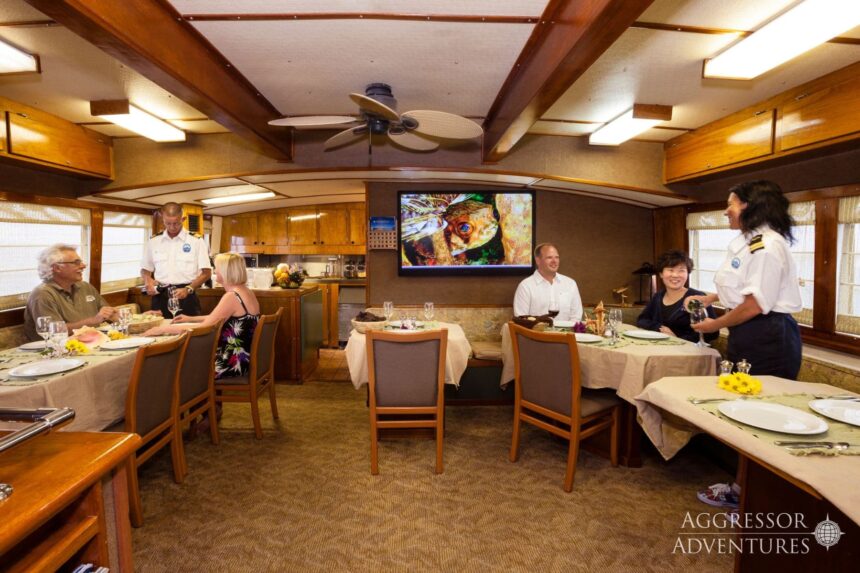 Guests dine with Aggressor crew in the yacht's saloon during dinner