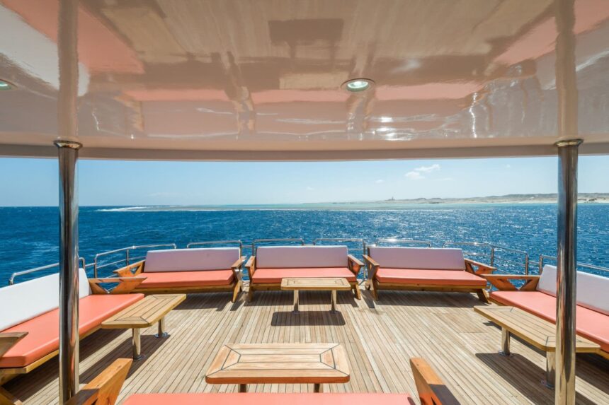 Shaded sun deck with pink cushioned benches overlooking the Red Sea coastline