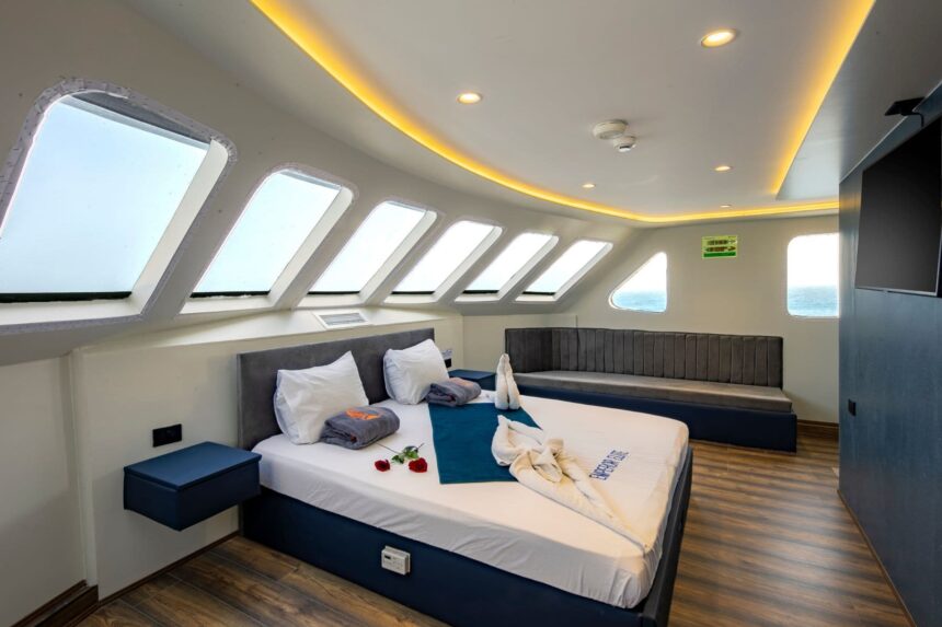 Twin cabin aboard the Emperor Elite lined with windows along the hull