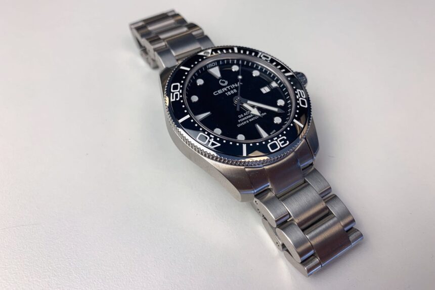 Certina DS Action Diver with black dial and bezel on a steel bracelet, shot on a white surface