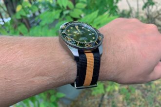 Certina DS Action Diver worn on our reviewer's wrist, green dial and titanium case on a black and tan NATO strap