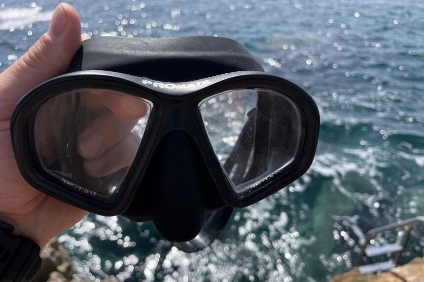 Our tester holding up the Promate Spectrum mask by the sea, showing its two lenses