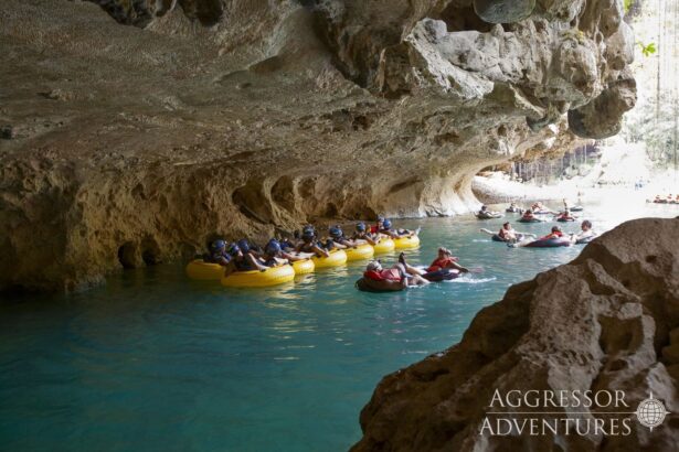 Groups floating on inflatable tubes through a cave river during a Belize land excursion