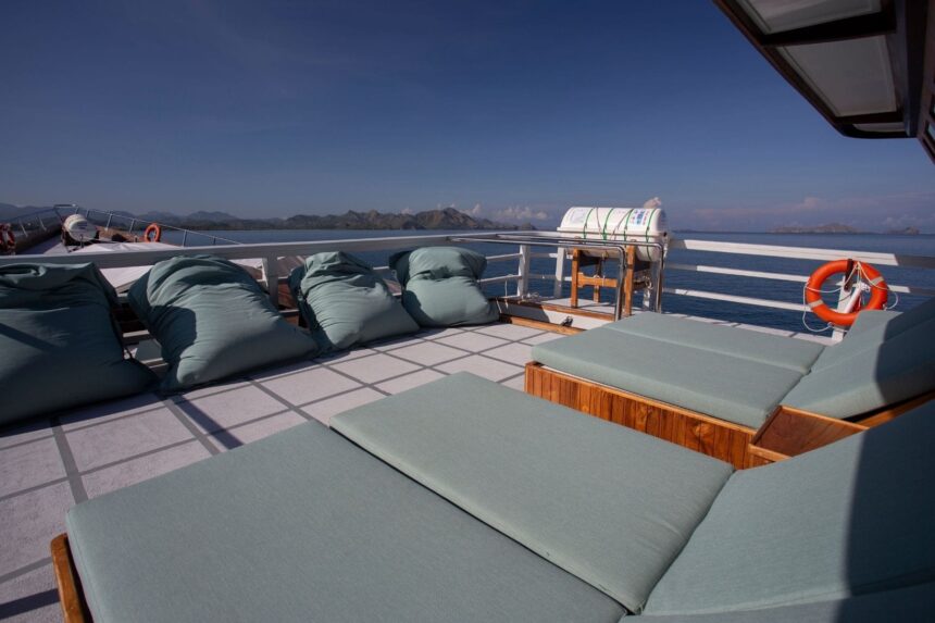 cushioned lounge seating with a life ring on the sun deck of a liveaboard