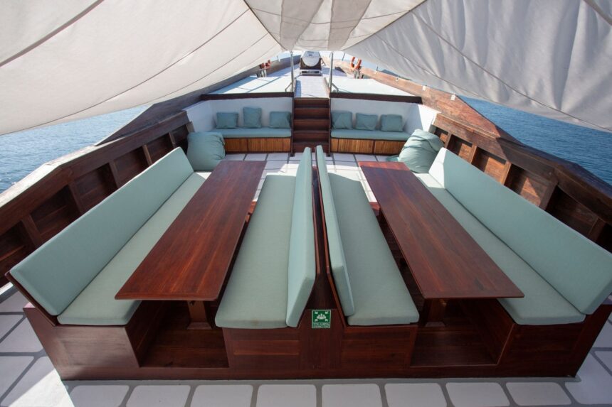shaded lounge and dining seating on the bow deck of a liveaboard under sail canopy