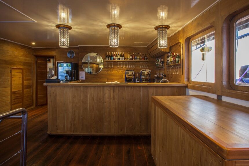 wooden bar area on a liveaboard stocked with bottles and glassware
