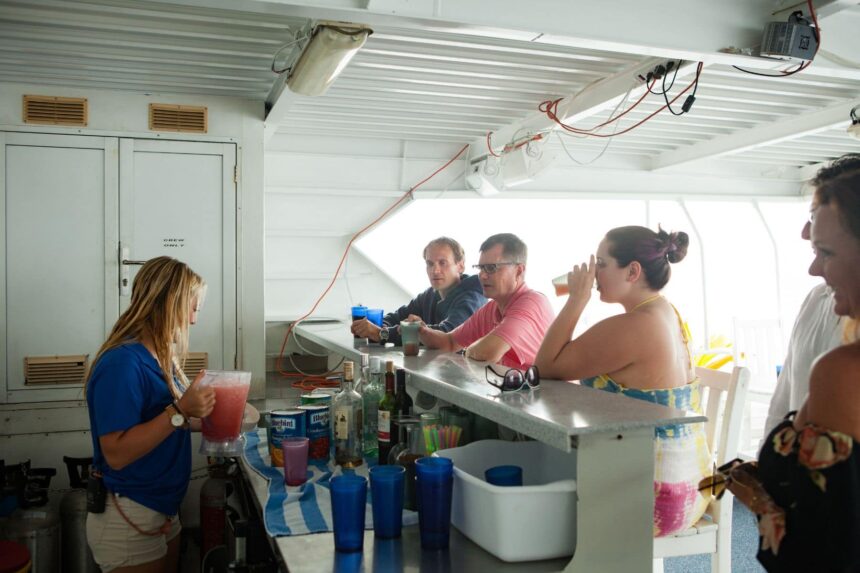 A crew member mixing drinks at the Aqua Cat's onboard bar for guests