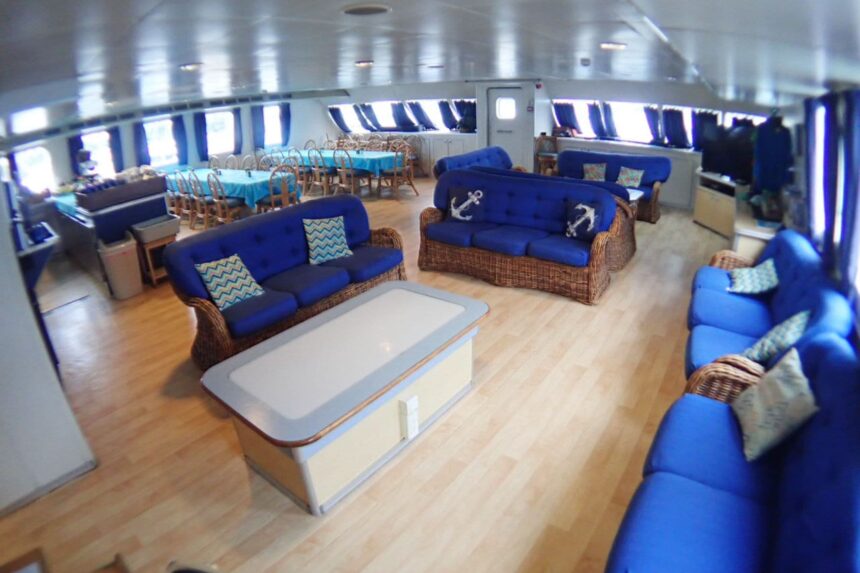 Blue upholstered lounge seating and sofas in the Aqua Cat's onboard salon