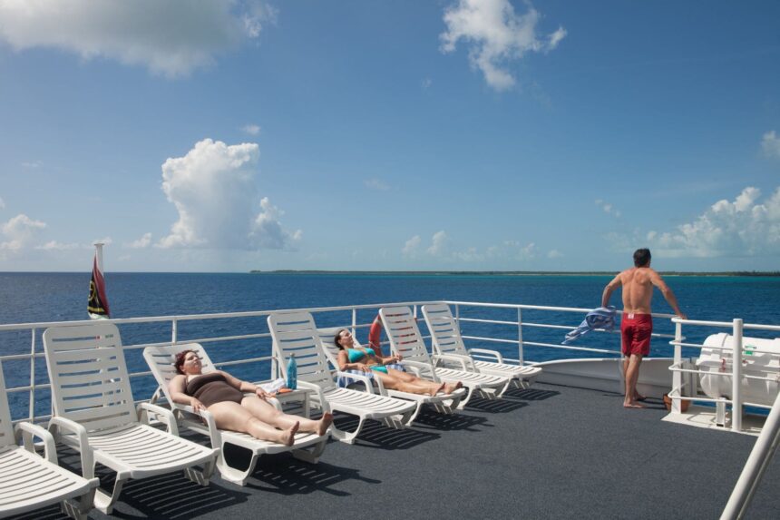 Guests relaxing on sun loungers on the Aqua Cat's upper deck