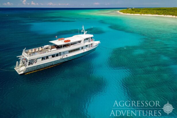 Aerial view of the Cayman Aggressor IV anchored beside a turquoise reef and island