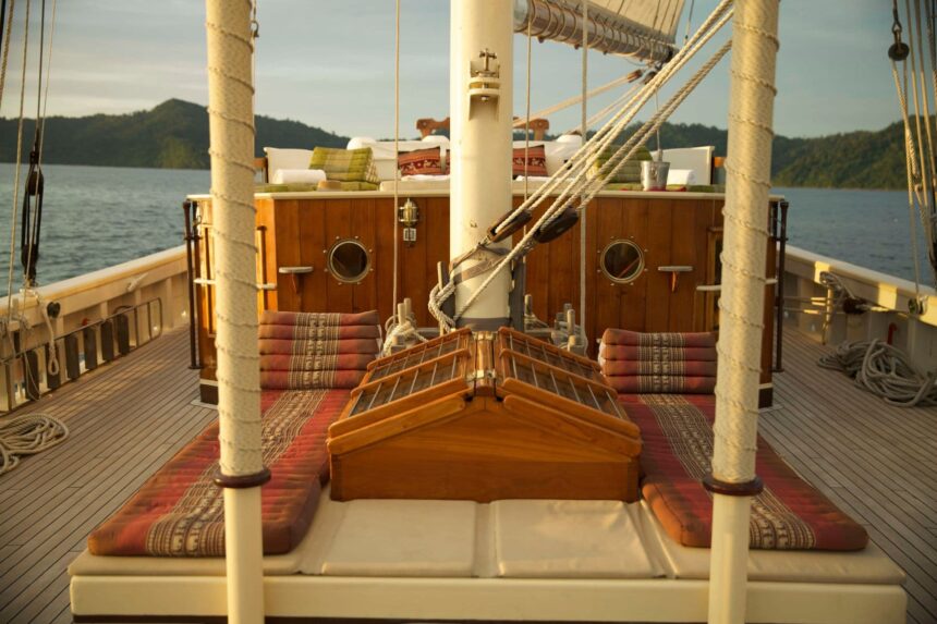 Cushioned bow seating area of the Emperor Raja Laut with view over the deck at golden hour